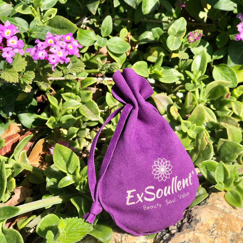 A ExSoullent Branded Flannel bag with yoni eggs inside and lush greens surrounding it